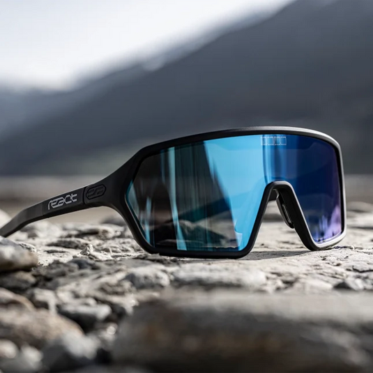 REACT Sunglasses Rev with adjustable temples and quick-tint lenses on rocky surface.